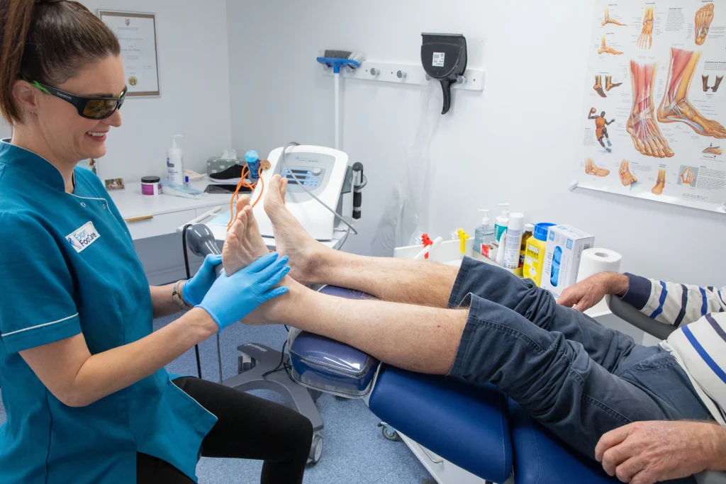 Podiatrist performing shockwave therapy on a patient's heel to treat plantar fasciitis